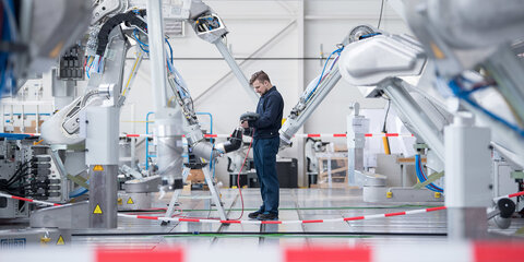 Ein Mitarbeiter testet einen Lackierroboter.