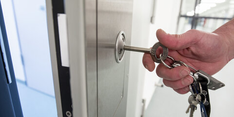 Ein Justizbeamter steckt in einem Untersuchungsgefängnis einen Schlüssel in eine Zellentür.