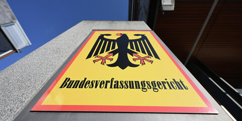 Ein Hinweisschild mit Bundesadler und dem Schriftzug Bundesverfassungsgericht, aufgenommen vor dem Bundesverfassungsgericht.
