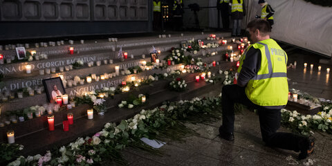 Ein Polizist kniet am 19.12.2017 an der Gedenkstätte für die Opfer des islamistischen Terroranschlags auf dem Weihnachtsmarkt an der Gedächtniskirche auf dem Breitscheidplatz in Berlin.