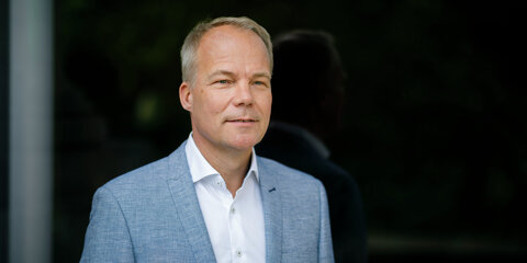 Matthias Miersch steht vor einem dunklen Hintergrund und schaut lächelnd in die Ferne.