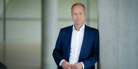 Matthias Miersch lehnt an einem Betonpfeiler und schaut frontal in die Kamera.