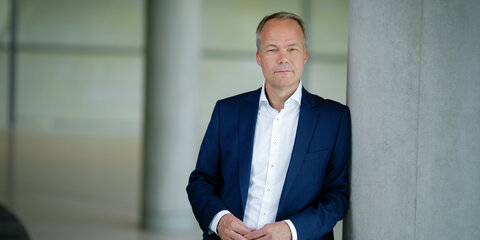Matthias Miersch lehnt an einem Betonpfeiler und schaut frontal in die Kamera.