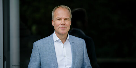 Matthias Miersch steht vor einem dunklen Hintergrund und schaut lächelnd in die Kamera.
