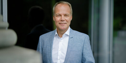 Matthias Miersch steht vor einem dunklen Hintergrund und schaut lächelnd in die Kamera.