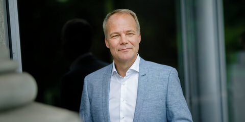 Matthias Miersch steht vor einem dunklen Hintergrund und schaut lächelnd in die Ferne.