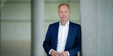 Matthias Miersch lehnt an einem Betonpfeiler und schaut frontal in die Kamera.