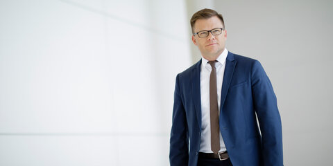 Carsten Schneider läuft einen Flur entlang.