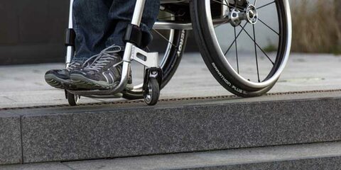 Eine Treppe stellt eine Barriere für einen Rollstuhlfahrer dar.