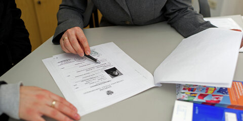 Unterlagendurchsicht: eine ausländische Arbeitnehmerin stellt einen Antrag auf Anerkennung ihres ausländischen Berufsabschlusses in Deutschland.