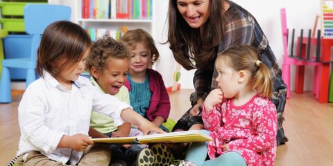 Erzieherin spielt mit Kindern im Kindergarten bzw. in der Kita