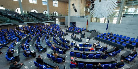 Blick in den Plenarsaal des Bundestages mit Abgeordneten, die im Sicherheitsabstand zu einander sitzen.
