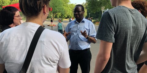 Karamba Diaby steht vor Bürgern und unterhält sich.
