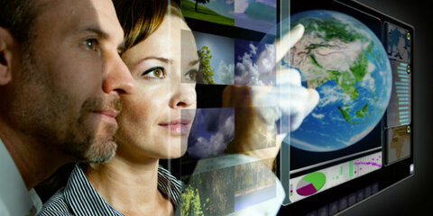 Mann und Frau vor futuristischem Touchscreen-Display