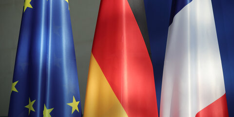 Die Fahnen der EU, Deutschlands und Frankreichs hängen im Kanzleramt.