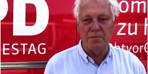 Uli Freese steht vor dem Dialogbus und spricht in die Kamera