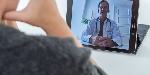 Eine Patientin während einer Videosprechstunde mit einem Arzt