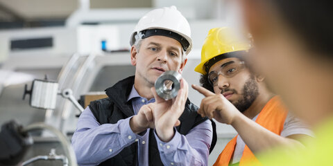 Vorgesetzter und Arbeiter, die sich über den Einsatz von Metall in der Industrie besprechen