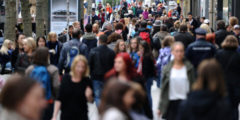 Passanten gehen durch eine Straße.