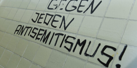Auf einer Wand steht die Aussage "Gegen jeden Antisemitismus"