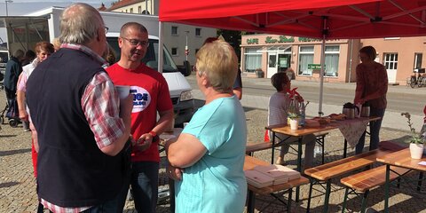 Frank Junge steht zusammen mit einem älteren Paar und unterhält sich.