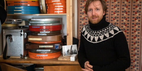 Der Stummfilmpianist Richard Siedhoff steht in seinem Arbeitszimmer vor einem Regal mit alten Filmdosen.
