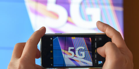 Ein Journalist fotografiert vor dem Start der Auktion von 5G-Mobilfunkfrequenzblöcken das Kürzel «5G» mit seinem Smartphone.