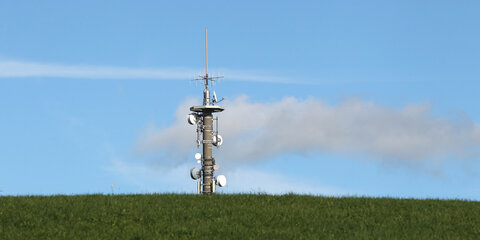 Ein Mobilfunkmast steht auf einer grünen Wiese bei Mauerstetten (Bayern)