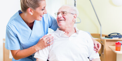 Junge Pflegekraft mit älterem Patienten