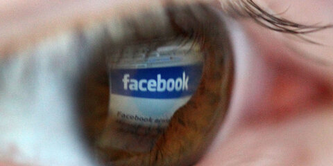 Das Logo der Internet-Seite von Facebook spiegelt in einer Pupille.