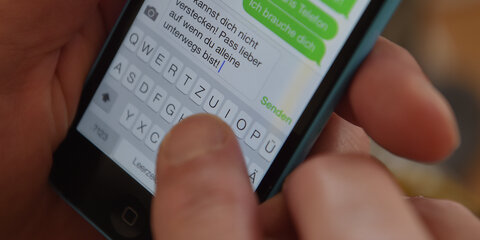 Eine Mann schreibt eine drohende Chat-Nachricht auf dem Smartphone.