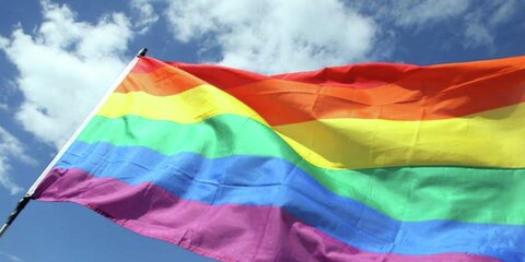 Regenbogenfahne vor blauem Himmel