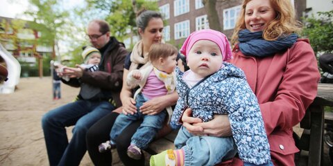 Eltern mit Kindern auf einem Spielplatz
