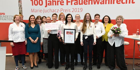 Die Gewinnerinnen des Marie-Juchacz-Preises stehen in eine Gruppe mit Andrea Nahles und schauen fröhlich in die Kamera.