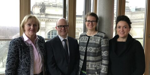 Ursula Schulte MdB, Arnaud Brizay, Carolin Krieger und Sarah Ryglewski stehen vor einem Fenster im Besprechungsraum. Im Hintergrund sieht man den Reichstag.
