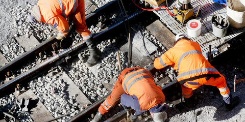 Ein Bautrupp der Bahn arbeitet auf Bahnstrecken am Gleisbett.