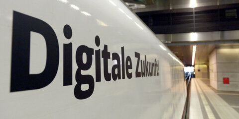 Der Schriftzug "Digitale Zukunft" ist am 27.05.2014 an einem Zug zusehen, der während einer Pressekonferenz an einem Gleis des Berliner Hauptbahnhofes steht. Die Bundesregierung und Deutsche Bahn wollen die digitalen Angebote der DB weiter stärken. Foto: Rainer Jensen/dpa