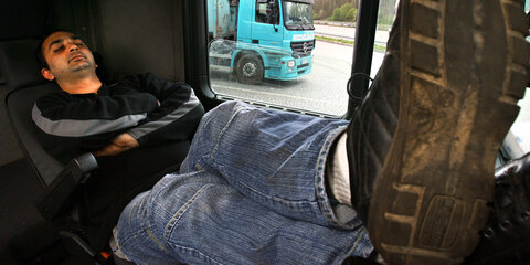 Ein LKW-Fahrer schläft in der Fahrerkabine.