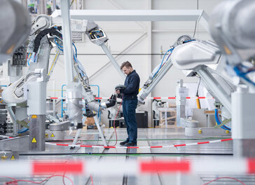 Ein Mitarbeiter testet einen Lackierroboter.
