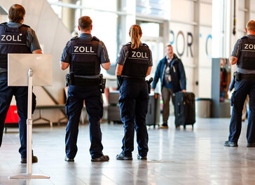 Zollbeamte stehen am Kieler Ostseekai.